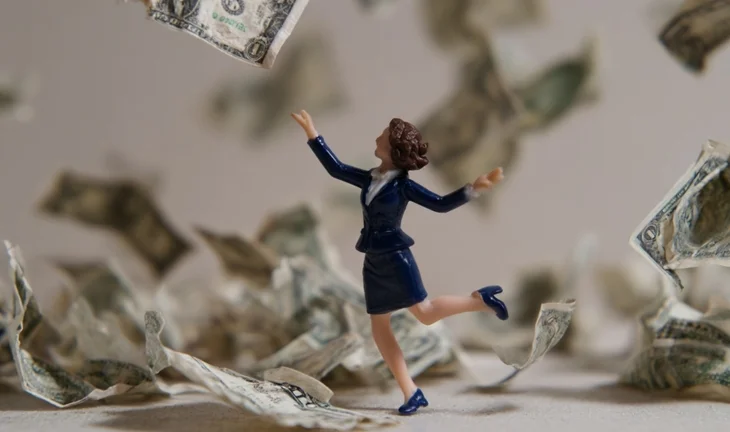 a plastic figurine dancing in money 