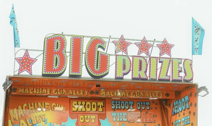 A fairground booth that says big prizes 